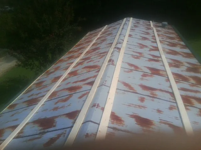 Rusted metal roof panels with new wood purlins before replacement — Storm Damage Roof Repair in Adkins by Roofing Brothers