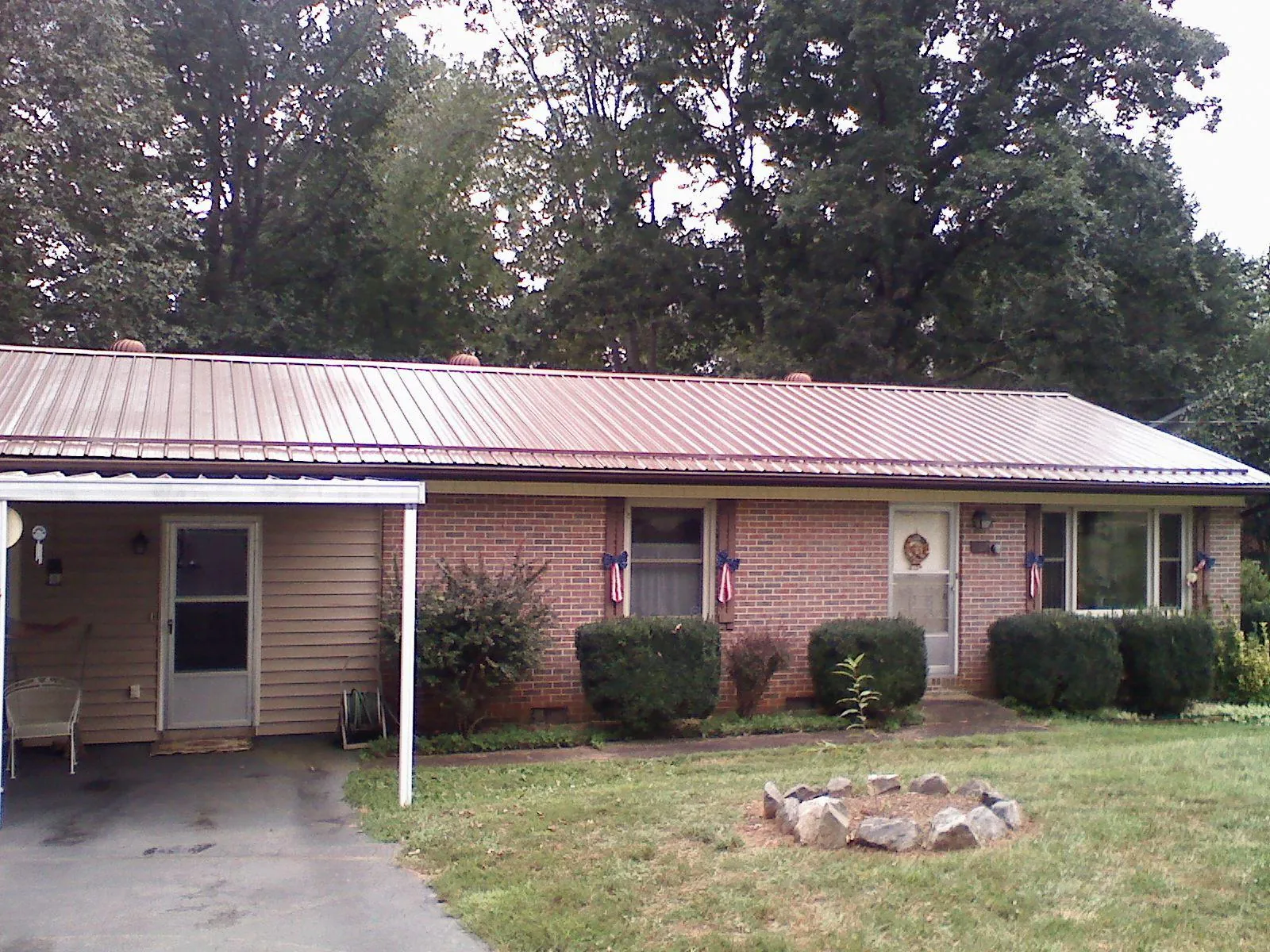 Bronze metal roof and carport on a brick ranch home — Roof Repair work by our crew in Adkins